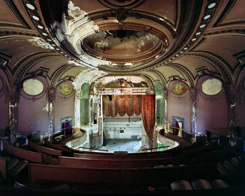 Photo taken from the upper seats of a theatre showing the interior of the main stage and the decoration of the walls